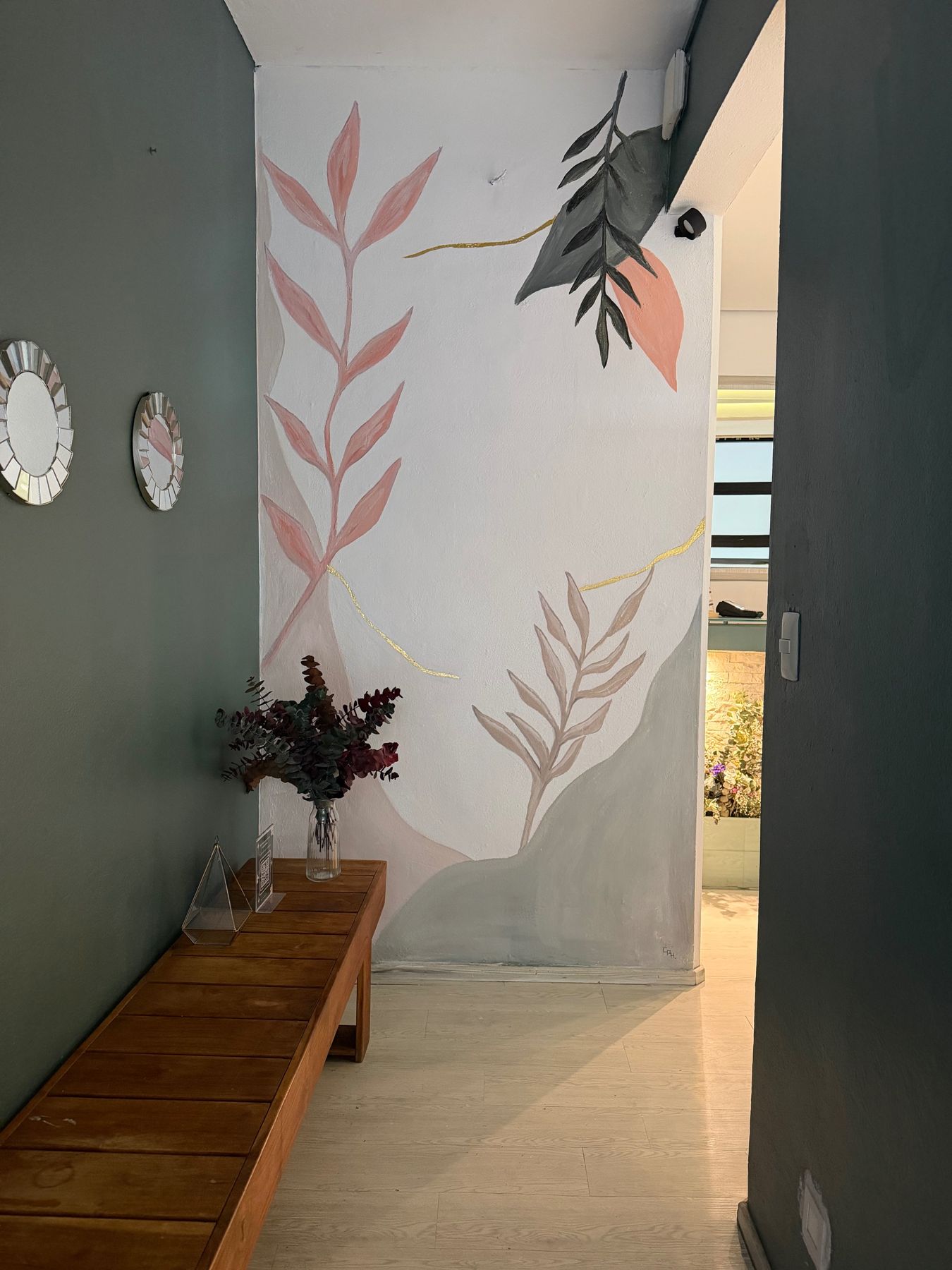 Mural de hojas pintado a mano en el pasillo